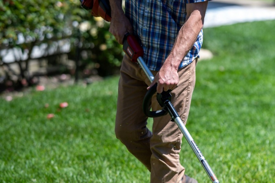 Person using a string trimmer on a lawn